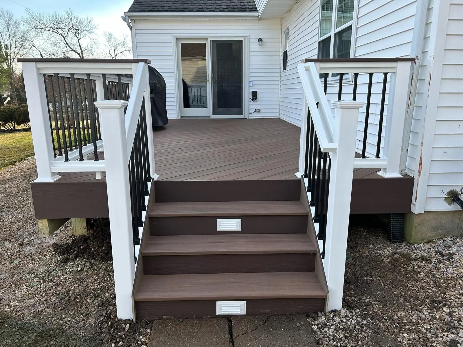 Composite deck stairs with white vinyl posts and black balusters